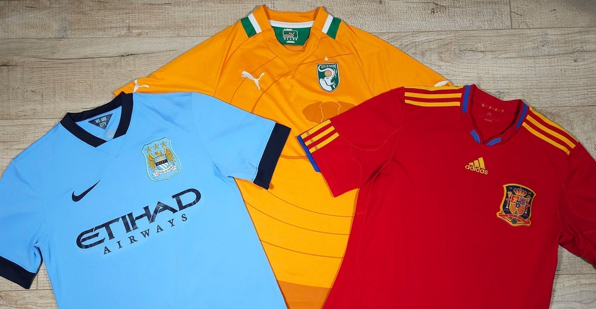 Nike, Puma and Adidas football shirts on wooden background